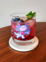 Axolotl rocks glass with drink on coaster